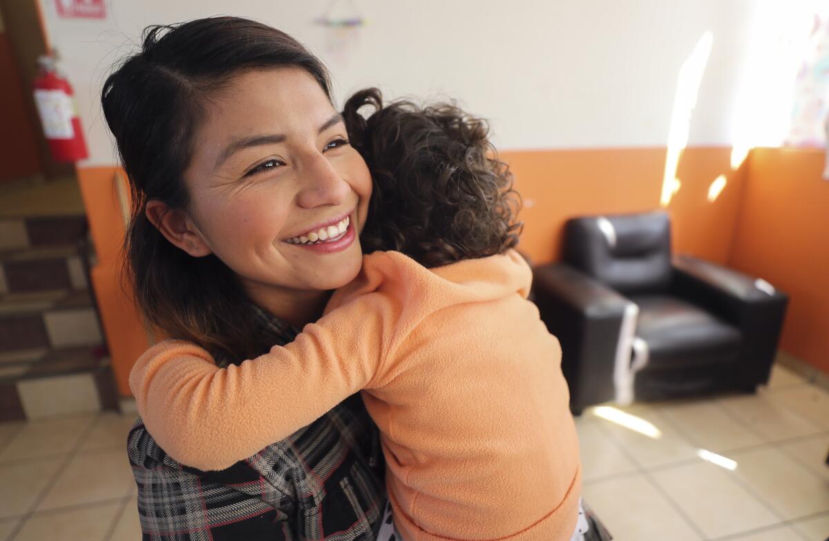 Rocío Martínez Pérez, de 23 años, quien creció y aún vive en el orfanatorio Hacienda, abraza a una niña en el mismo lugar el miércoles 30 de octubre de 2019 en Tijuana, México.