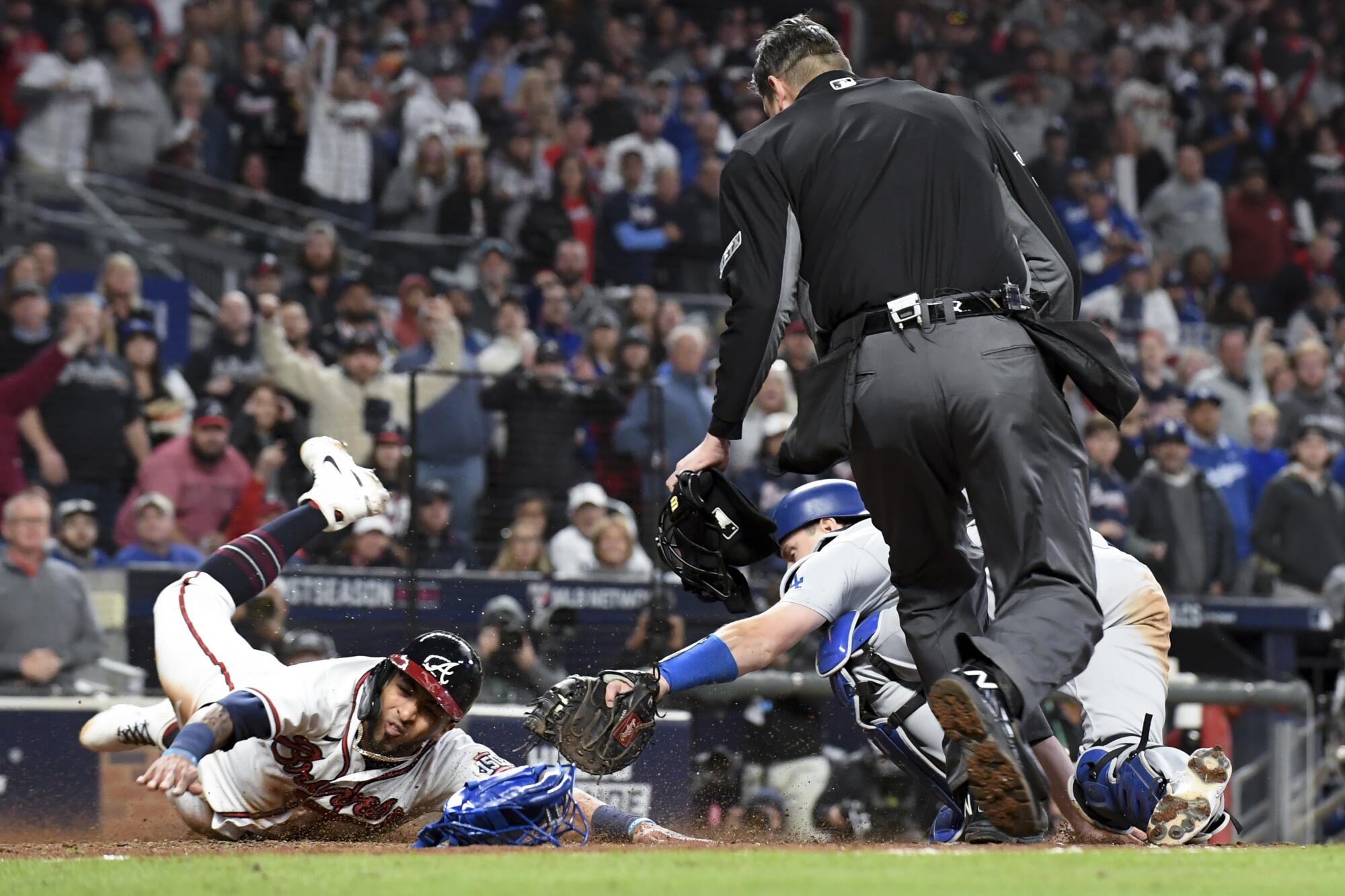 Atlanta Braves' Eddie Rosario, left, scores past the tag of Los Angeles Dodgers catcher Will Smith