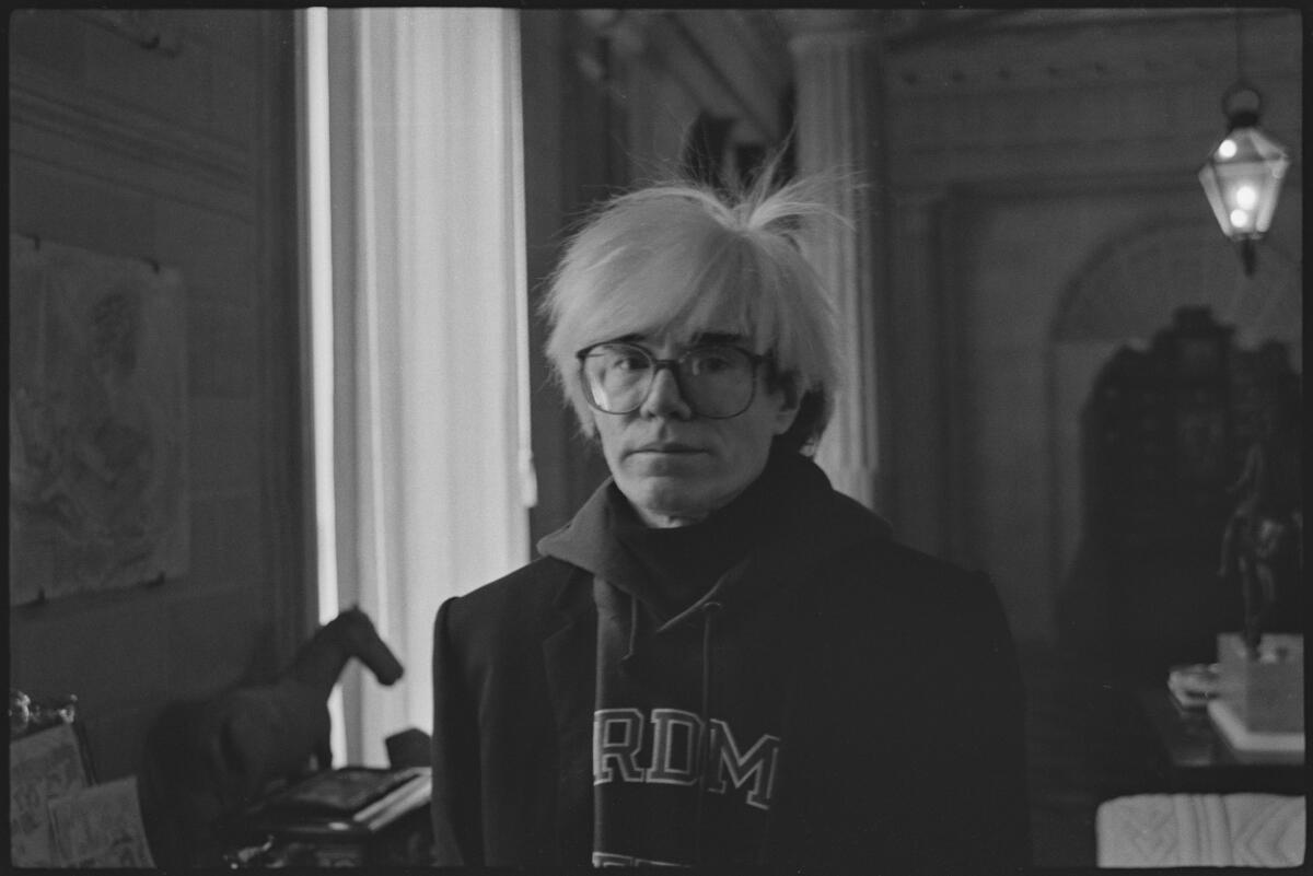 Andy Warhol looks at the camera.