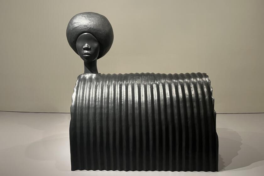 A stoneware sculpture by Simone Leigh features a woman's head in the style of African art attached to a quonset hut form