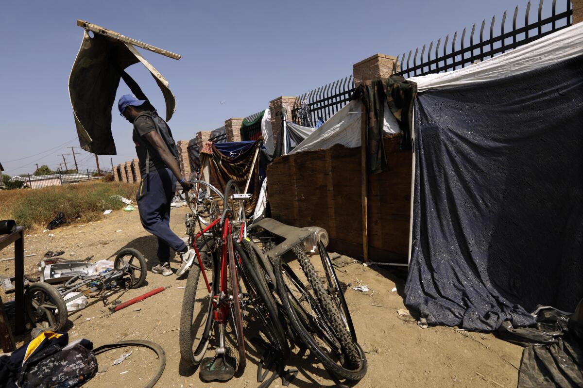 A man stands among bikes that have been taken apart.