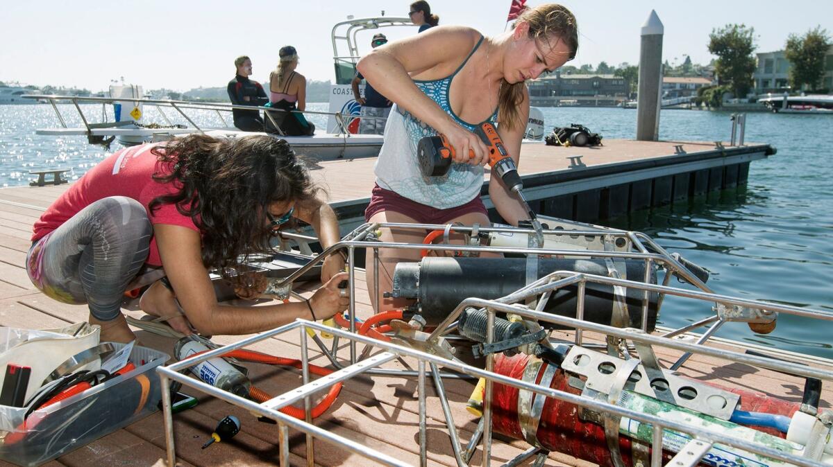 UC Davis Bodega Ocean Acidification Research Group members Melissa Ward, right, and Priya Shukla set up water chemistry sensor devices at Back Bay Science Center in Newport Beach.