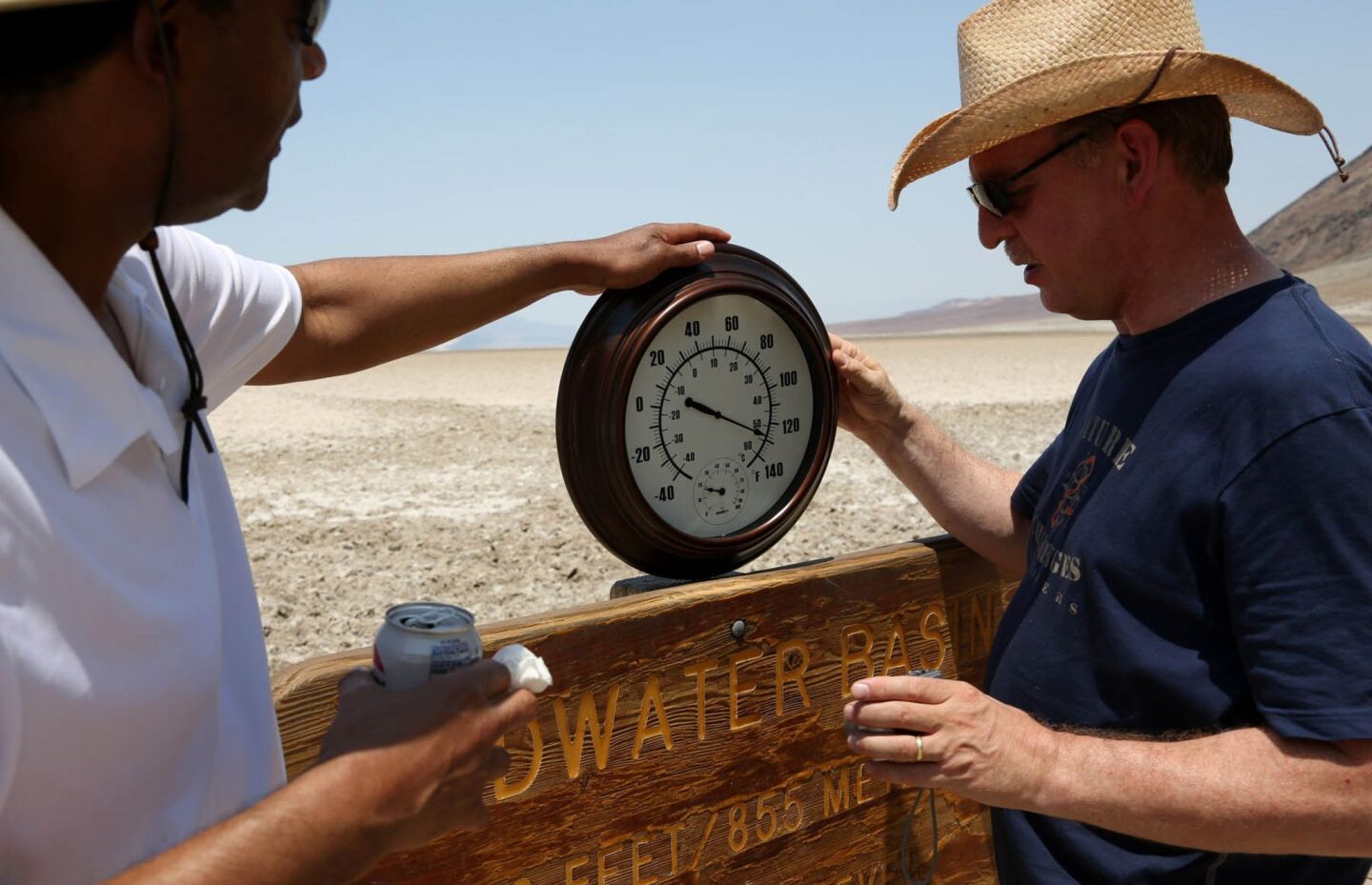 Randy Thomas, left, of Vacaville, Calif., helps Andreas Kinnen from Germany hold up a thermometer in Death Valley's Badwater Basin.