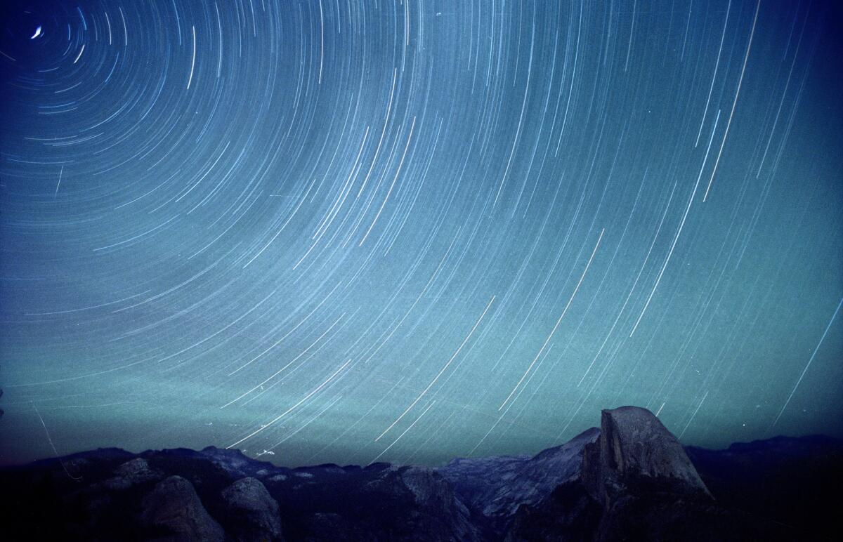 Chan, Bryan -- - Stars appear to swirl around the North Star in this time exposure at Glacier Point in Yosemite National Park. At right is Half dome. FILM IMAGE