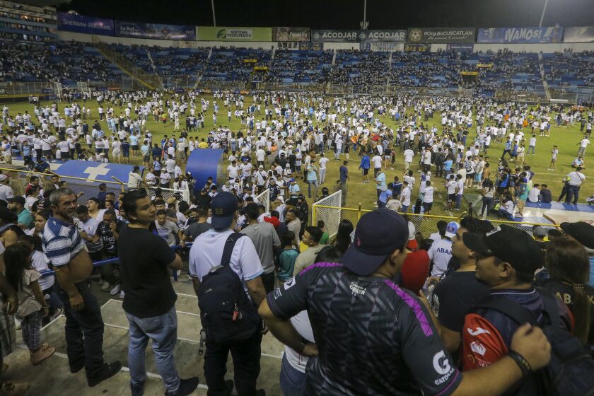 Hinchas en el campo del estadio Cuscatlán en San Salvador, El Salvador, el sábado 20 de mayo de 2023. Doce personas murieron y más de 100 resultaron lesionadas tras una estampida cuando la gente intentó derribar una puerta de acceso. (AP Foto/Milton Flores)