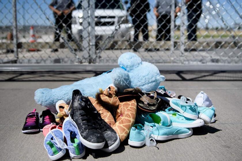 (FILES) In this file photo taken on June 21, 2018 (FILES) This June 21, 2018 file photo shows security personal standing before shoes and toys left at the Tornillo Port of Entry in Tornillo, Texas where minors crossing the border without proper papers have been housed after being separated from adults. Hundreds of immigrant parents and children separated at the US-Mexico border were in limbo on July 26, 2018, as American officials struggled to meet a court-set deadline for family reunification that was set to expire. A federal judge in California has ordered that all eligible migrant families be brought back together by 6:00 pm (2200 GMT) Thursday July 26, 2018. / AFP PHOTO / Brendan SmialowskiBRENDAN SMIALOWSKI/AFP/Getty Images ** OUTS - ELSENT, FPG, CM - OUTS * NM, PH, VA if sourced by CT, LA or MoD **
