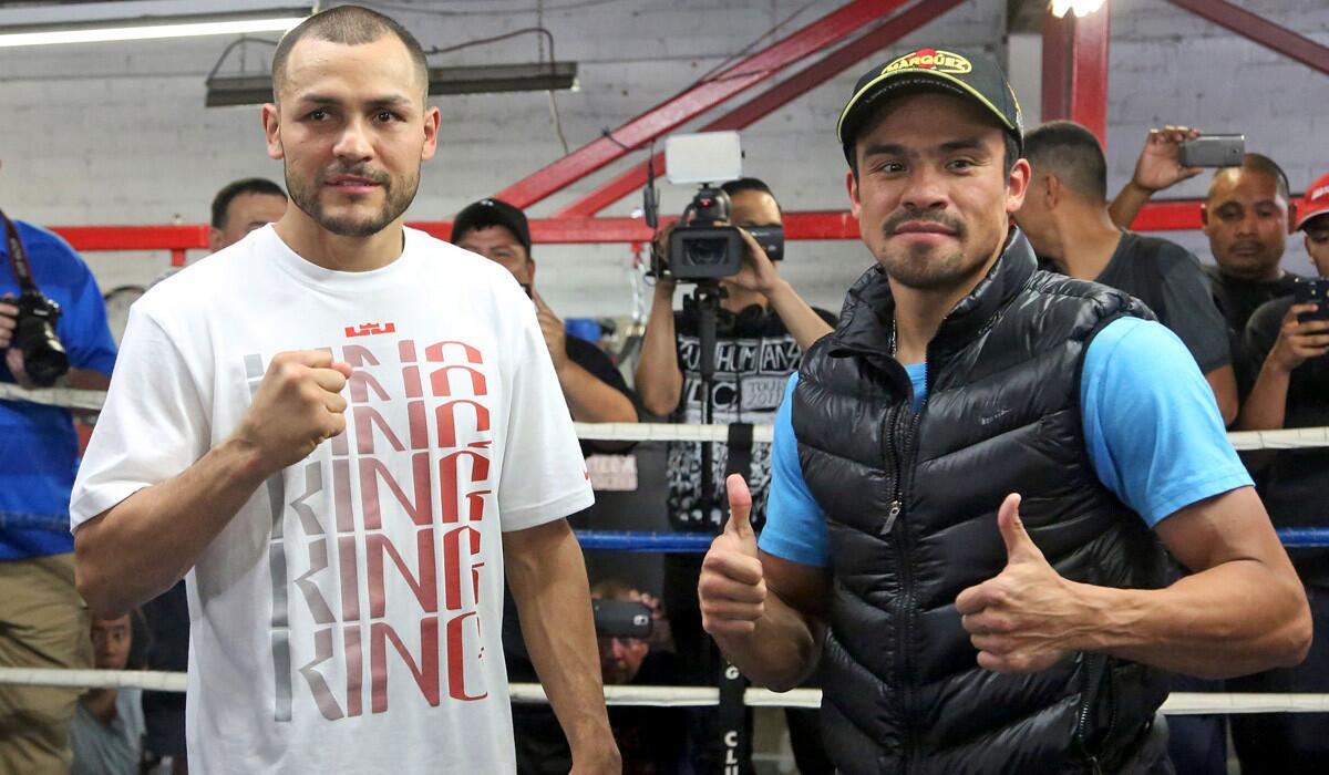 Mike Alvarado, left, and Juan Manuel Márquez pose in the ring during a media workout at the Azteca Boxing Club in Bell on Wednesday.