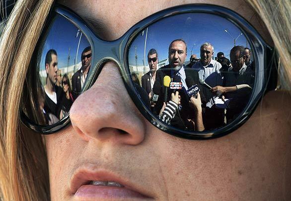 A supporter's sunglasses provide a view of right-wing leader Avigdor Lieberman of the Yisrael Beiteinu (Israel Our Home) party as he speaks to the media at the Kerem Shalom border crossing just outside the Gaza Strip.
