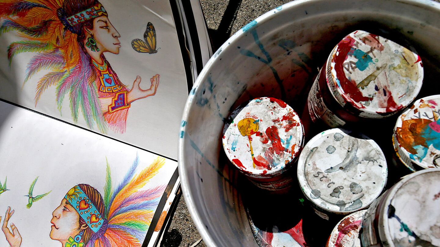 Preliminary sketches and paint used by volunteers on a mural along Van Nuys Boulevard.