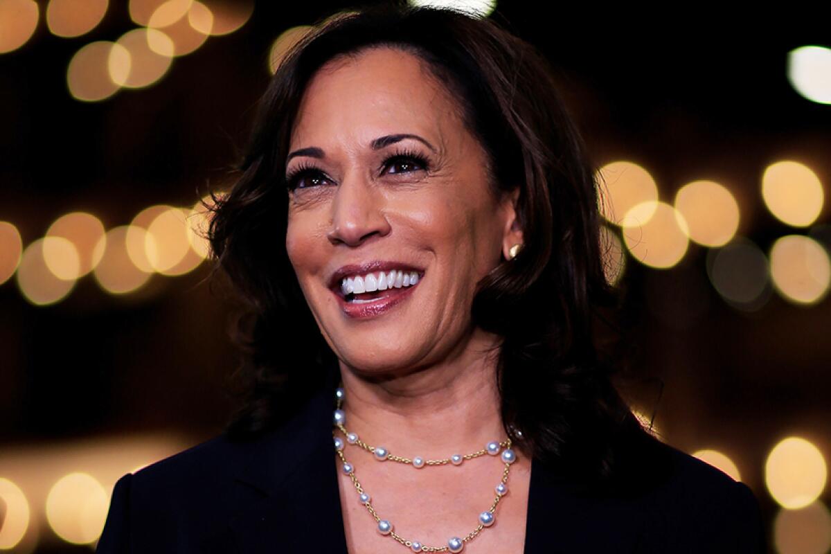 Vice President Kamala Harris smiles in front of lights