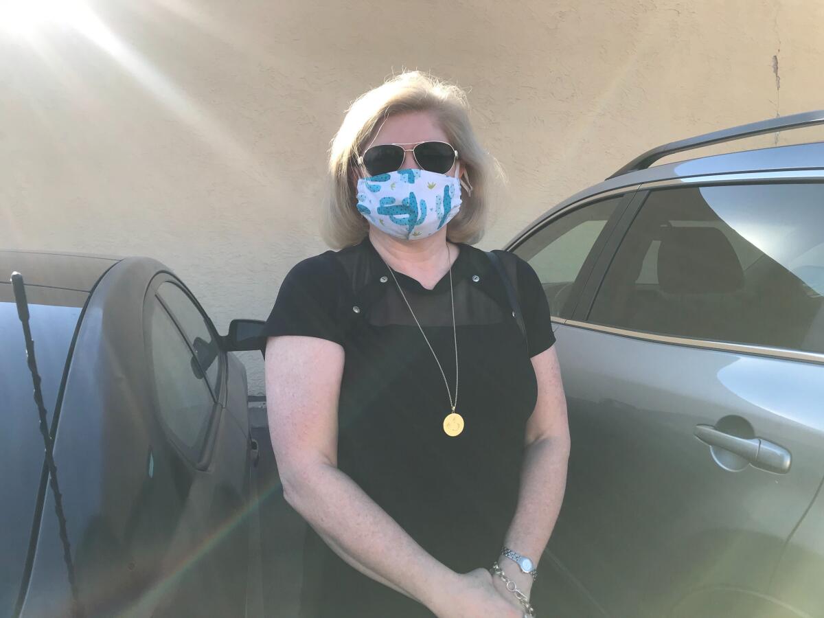 Ramona Dameron stands outside her car after voting early.