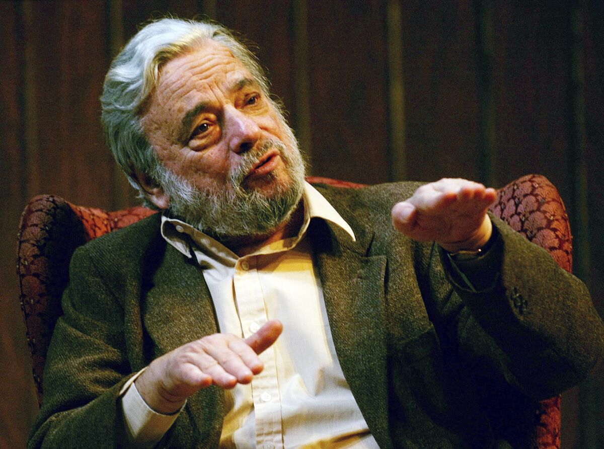 Stephen Sondheim gestures while he sits in a chair and talks