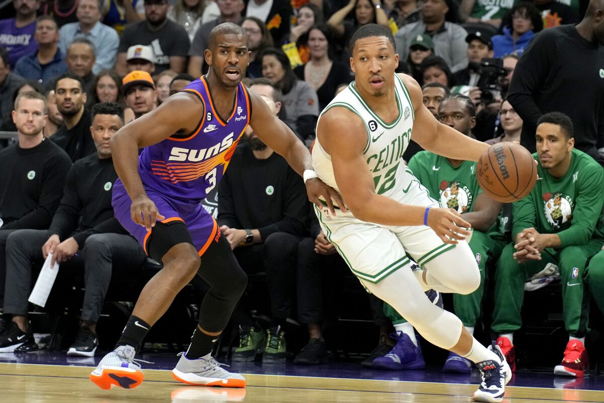 El jugador de los Celtics de Boston Grant Williams pasa junto al jugador de los Suns de Phoenix Chris Paul (3) en la primera mitad de su juego de NBA, el miérocles 7 de diciembre de 2022, en Phoenix. (AP Foto/Rick Scuteri)