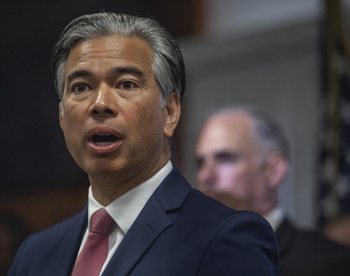 A man in a suit speaks at a news conference.