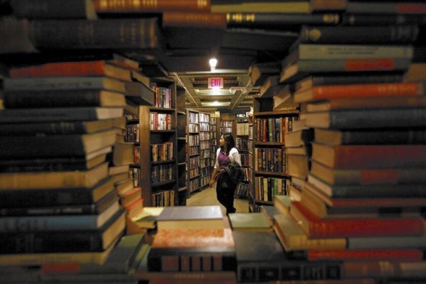 A visitor is framed by a portal surrounded by books in the Labyrinth on the second floor of the Last Bookstore in downtown Los Angeles.