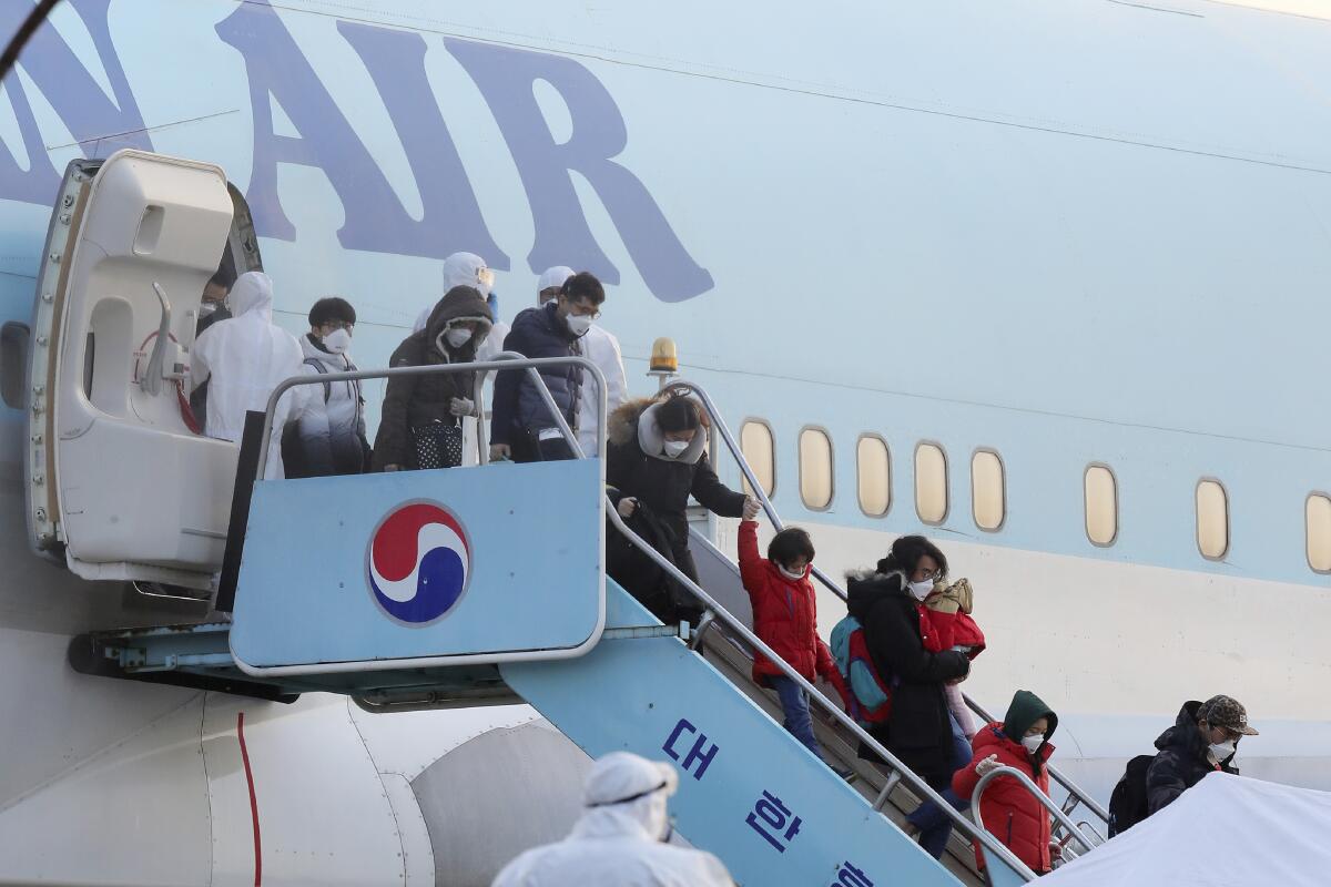 South Koreans evacuated from Wuhan, China, disembark from a chartered flight in Seoul on Friday.