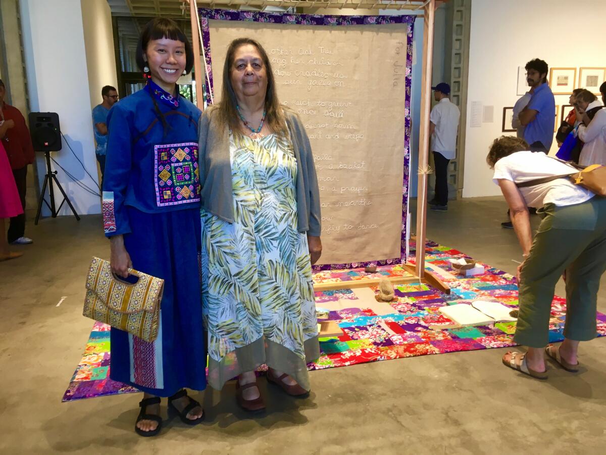 Julia Bogany and iris yirei hu stand in front of textile art.