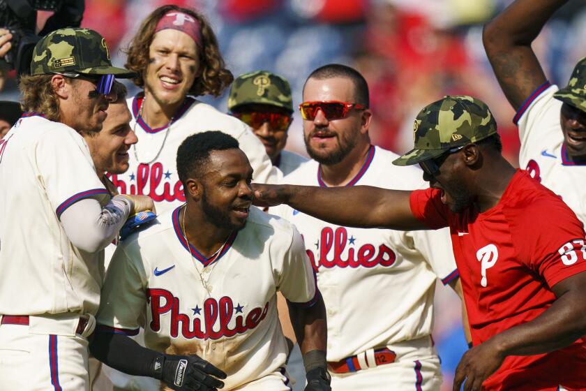 Philadelphia Phillies' Roman Quinn, second from front left, celebrates with teammates.