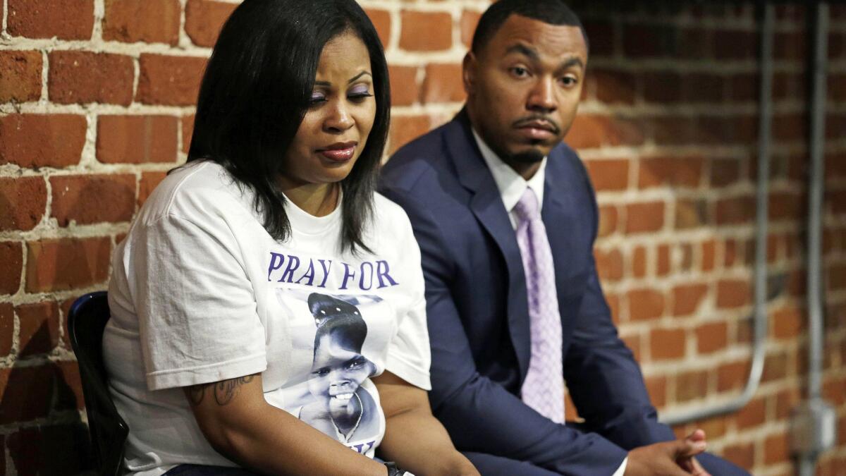 Nailah Winkfield, left, and Omari Sealey, the mother and uncle of Jahi McMath, listen to doctors speak during an October 2014 news conference in San Francisco.