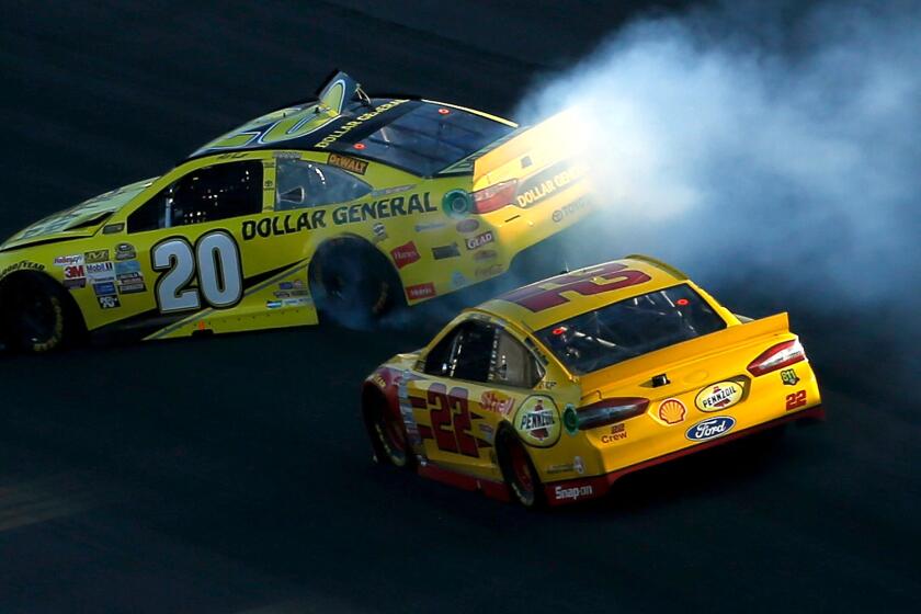 The car of NASCAR driver Matt Kenseth (20) spins out in front of Joey Logano (22) late in the Sprint Cup Series Hollywood Casino 400 at Kansas Speedway on Oct. 18.
