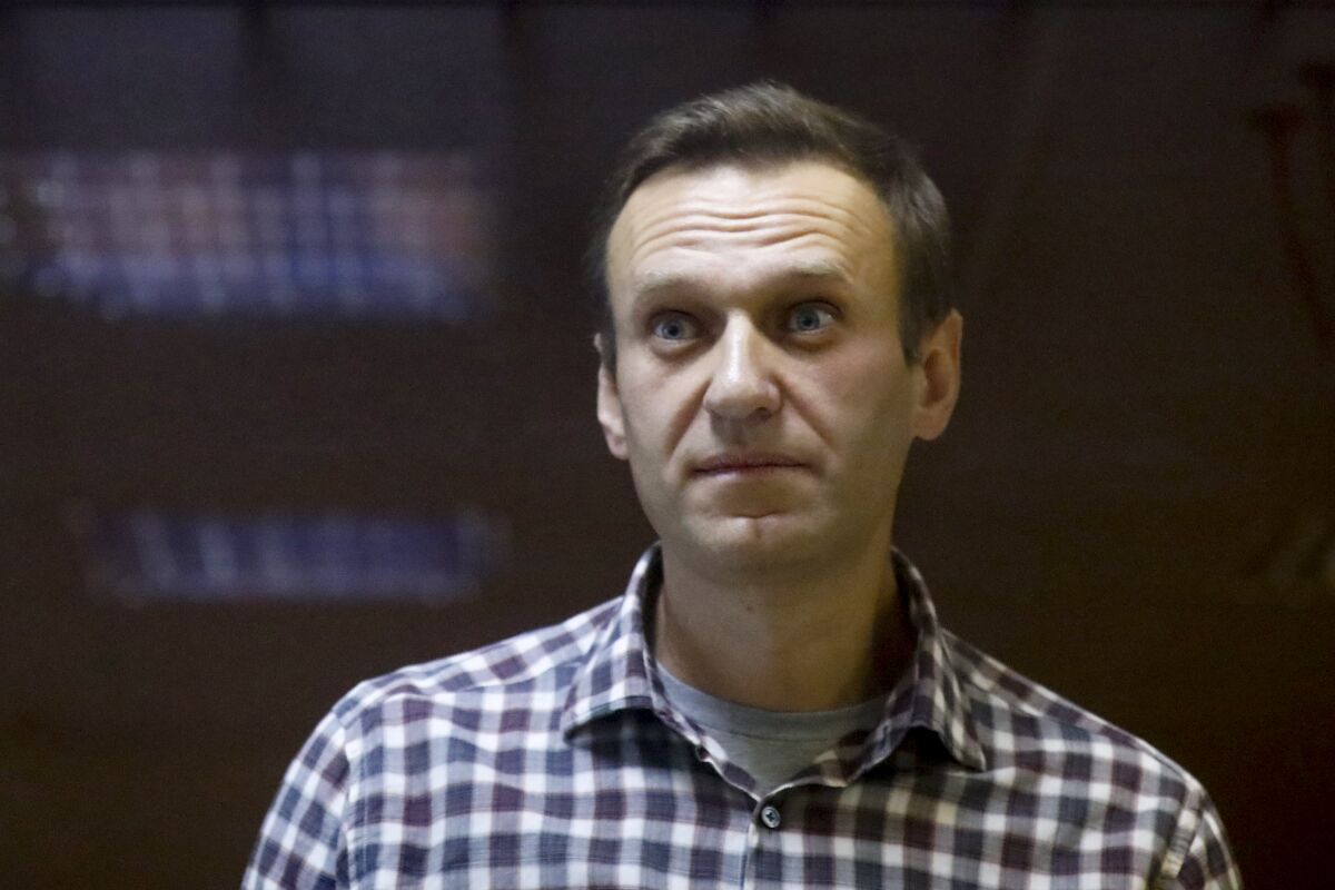FILE - In this file photo taken on Saturday, Feb. 20, 2021, Russian opposition leader Alexei Navalny stands in a cage in the Babuskinsky District Court in Moscow, Russia. Russian authorities have levied new criminal charges against imprisoned opposition leader Alexei Navalny. Russia's Investigative Committee on Wednesday Aug. 11, 2021, said it has charged Navalny with creating a non-profit organization that infringes on people's rights, a criminal offense punishable by up to four years in prison. (AP Photo/Alexander Zemlianichenko, File)