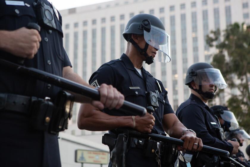 LOS ANGELES, CA - MAY 27: Los Angeles Police Department officers form a police line in riot gear after a Black Lives Matter Protest in solidarity with other national demonstrations to show outrage over the death of George Floyd in downtown Los Angeles on Wednesday, May 27, 2020 in Los Angeles, CA. (Gabriella Angotti-Jones / Los Angeles Times)