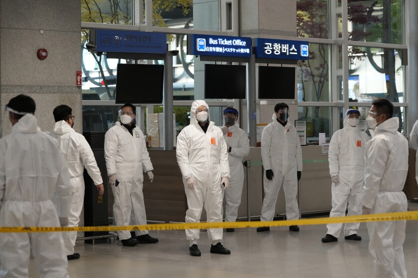 Quarantine officers wait to guide travelers at the arrival hall of the Incheon International Airport In Incheon, South Korea, Wednesday, Dec. 1, 2021. South Korea's daily jump in coronavirus infections exceeded 5,000 for the first time since the start of the pandemic, as a delta-driven surge also pushed hospitalizations and deaths to record highs. (AP Photo/Ahn Young-joon)
