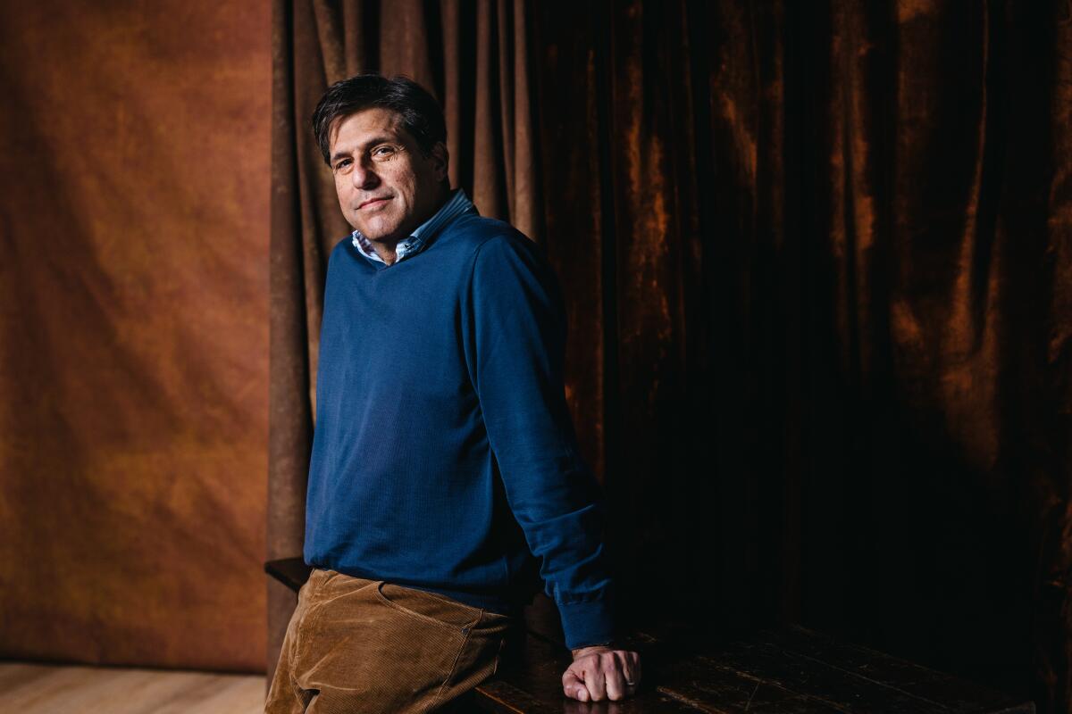 Hollywood executive Jonathan Glickman poses in front of a brown backdrop while wearing a blue sweater.