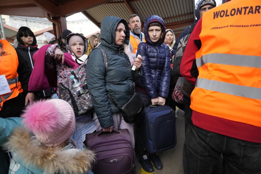 Refugees board a train.