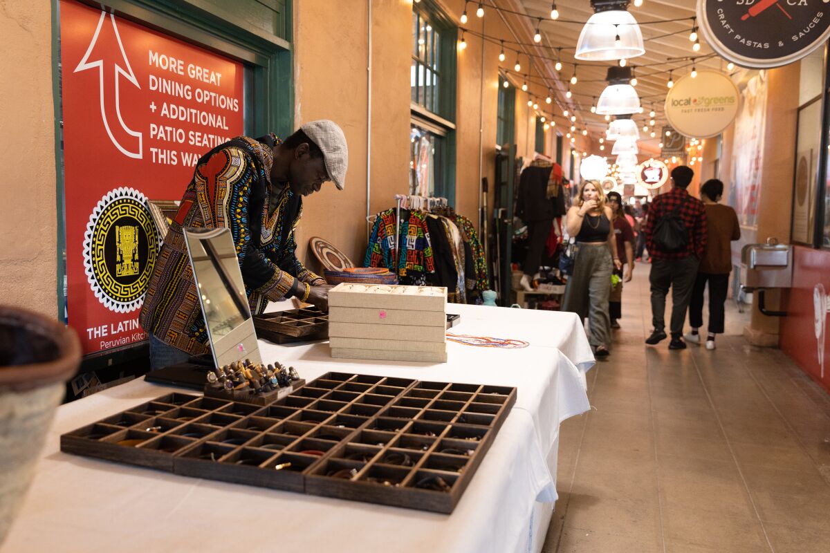 Thiam Ousmane, business owner of African Connection, sets up his stall at Liberty Public Market on Christmas Eve.