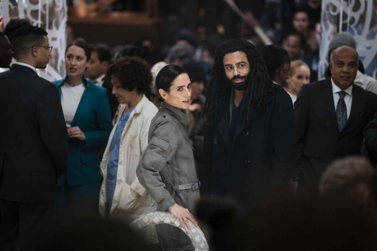 Jennifer Connolly and Daveed Diggs stand with a crowd of people in "Snowpiercer."