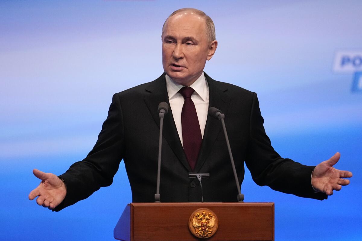 El presidente de Rusia, Vladímir Putin hace un gesto durante una visita a su sede 