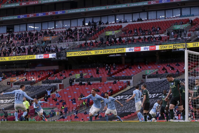 Manchester City's Aymeric Laporte, center, celebrates after scoring the opening goal during the English League Cup final soccer match between Manchester City and Tottenham Hotspur at Wembley stadium in London, Sunday, April 25, 2021. (AP Photo/Alastair Grant)