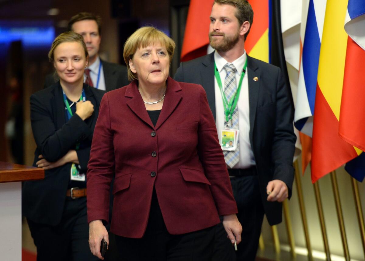 German Chancellor Angela Merkel, center, departs the European Union summit in Brussels.