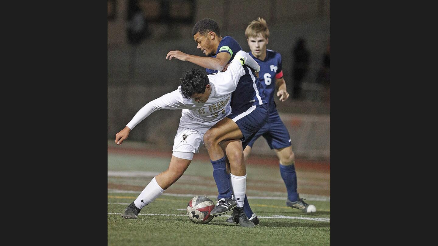 St. Francis' Sebastyan Enriquez and Flintridge Prep's Garrett Gains battle for the ball in a small scrum that ends with a yellow card for Gains in a nonleague boys' soccer game at St. Francis High School on Wednesday, December 6, 2017.