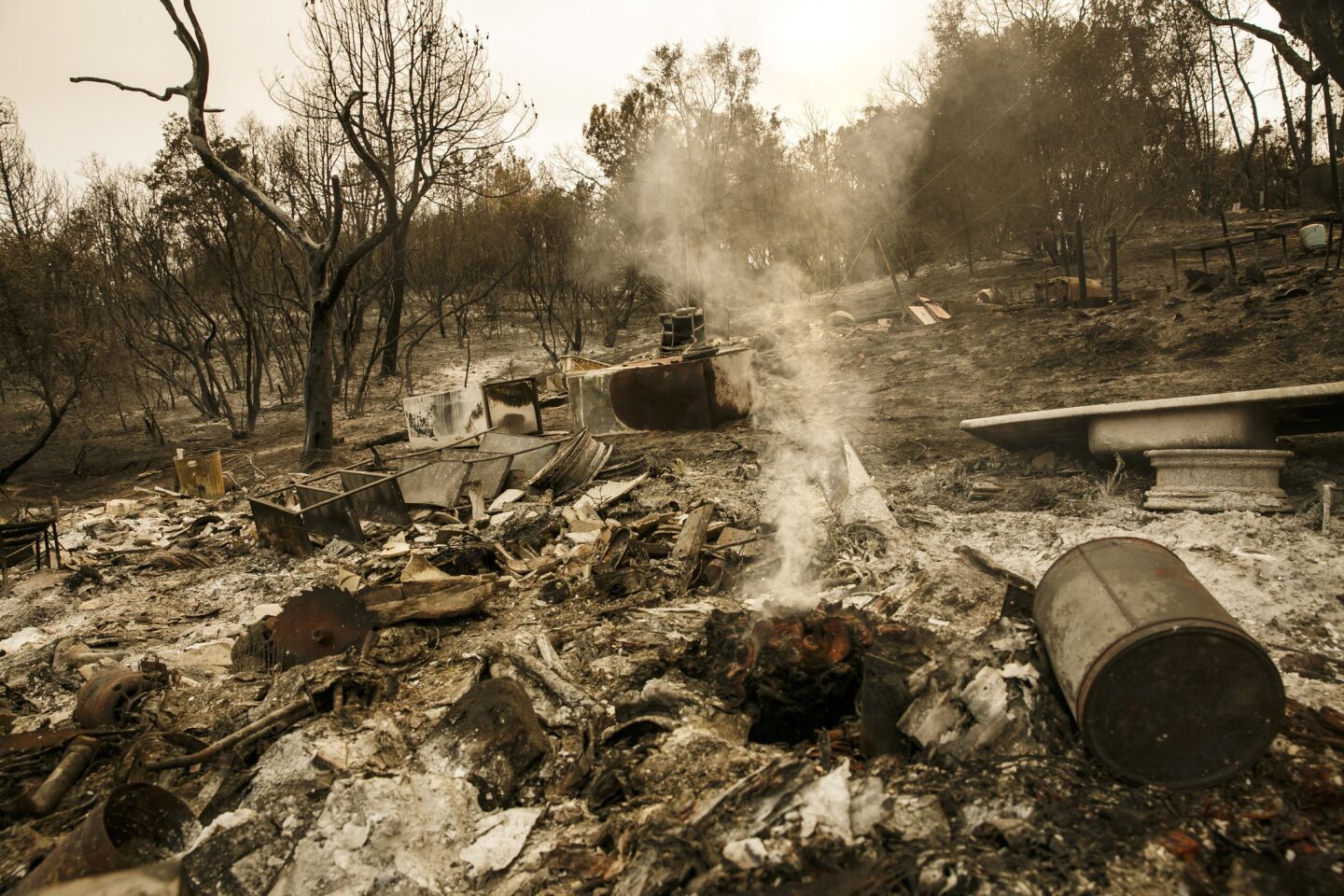 The ruins of a residential neighborhood along Highway 140 lie smoldering after the Detwiler wildfire burned through the area outside of Mariposa.