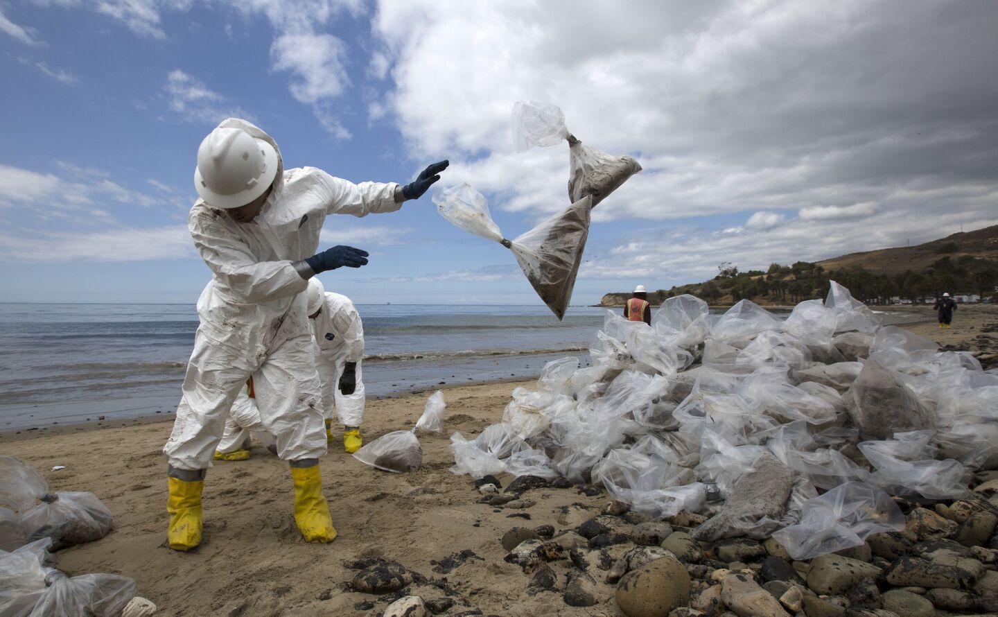 Patriot Environmental Services employees pile bags of oil-contaminated sand on the shoreline at Refugio State Beach near Santa Barbara.