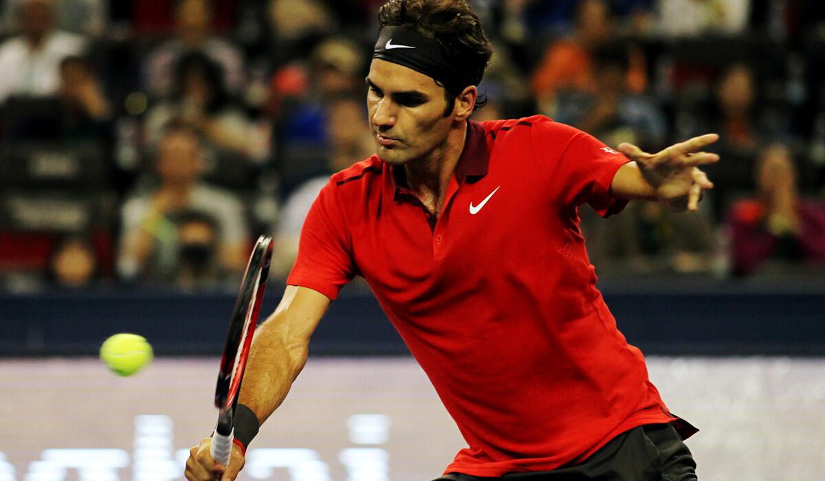 Roger Federer volleys a shot against Gilles Simon during the Shanghai Masters championship match on Sunday.