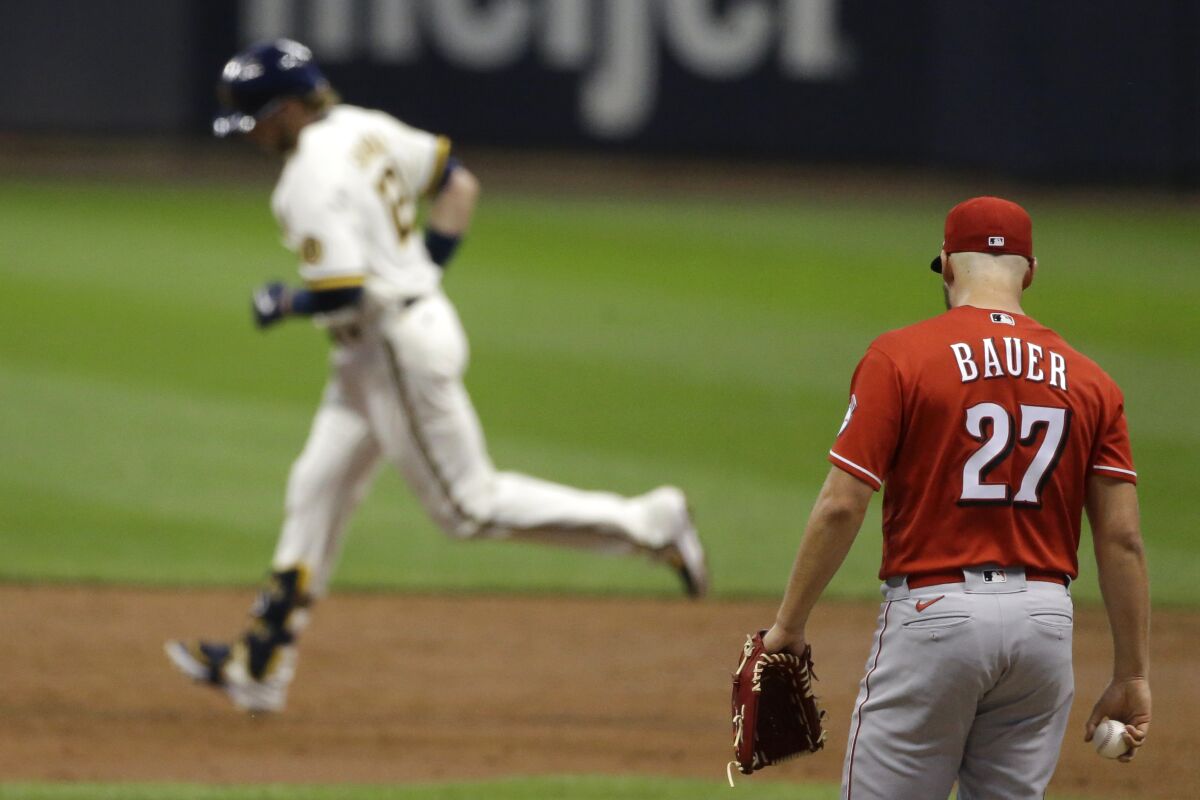 Cincinnati Reds' Trevor Bauer (27) walks back to the mound after giving up a two-run home run to Milwaukee Brewers' Justin Smoak (12) during the third inning of a baseball game Monday, Aug. 24, 2020, in Milwaukee. (AP Photo/Aaron Gash)