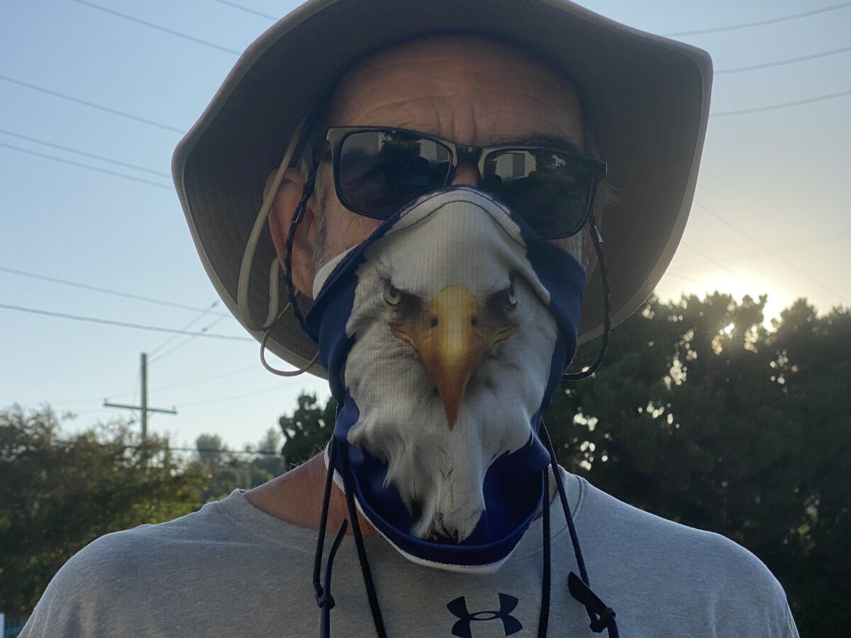 Chaminade football coach Ed Croson wears his Eagles mask while directing his team through a conditioning program.