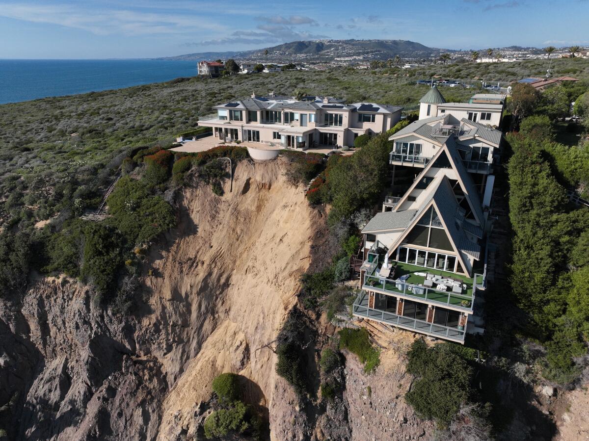 An aerial view shows three large homes in Dana Point on a cliff where a landslide occurred in early February.