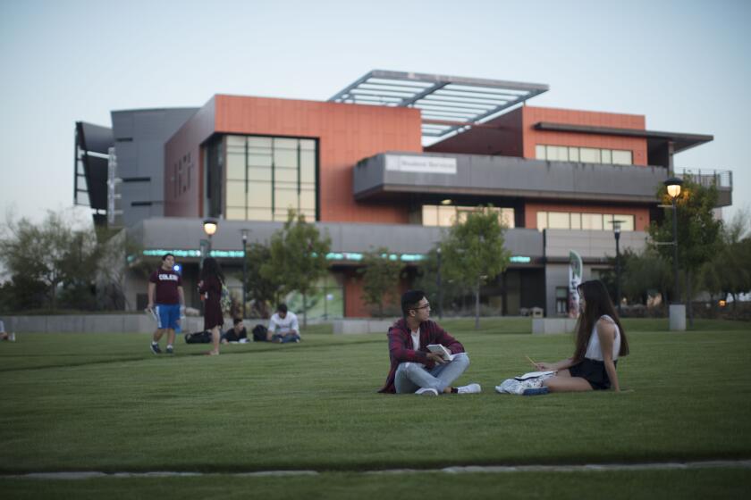 Students sit outside Student Services on the Miramar College campus.