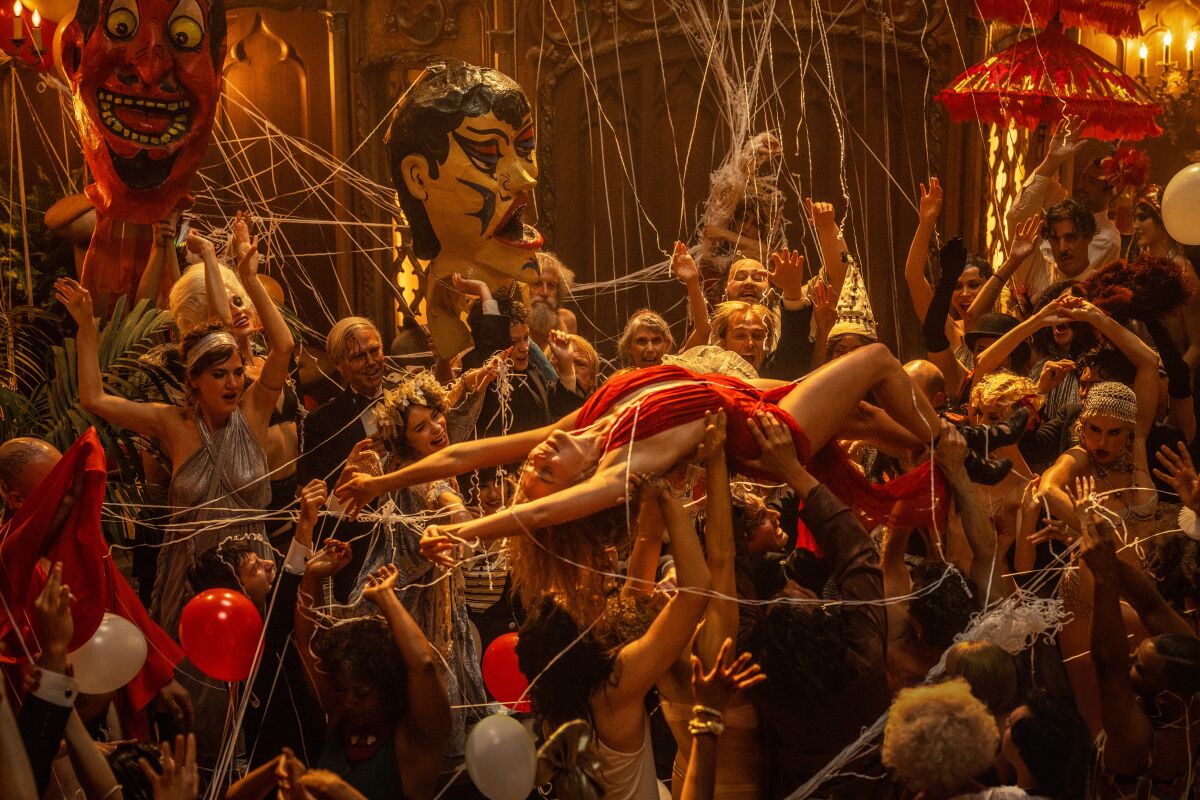 A woman crowd surfs at a wild party in a scene from "Babylon."