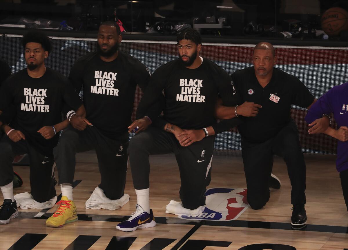 Los Angeles Lakers' LeBron James, second from left, wears a Black Lives Matter shirt.