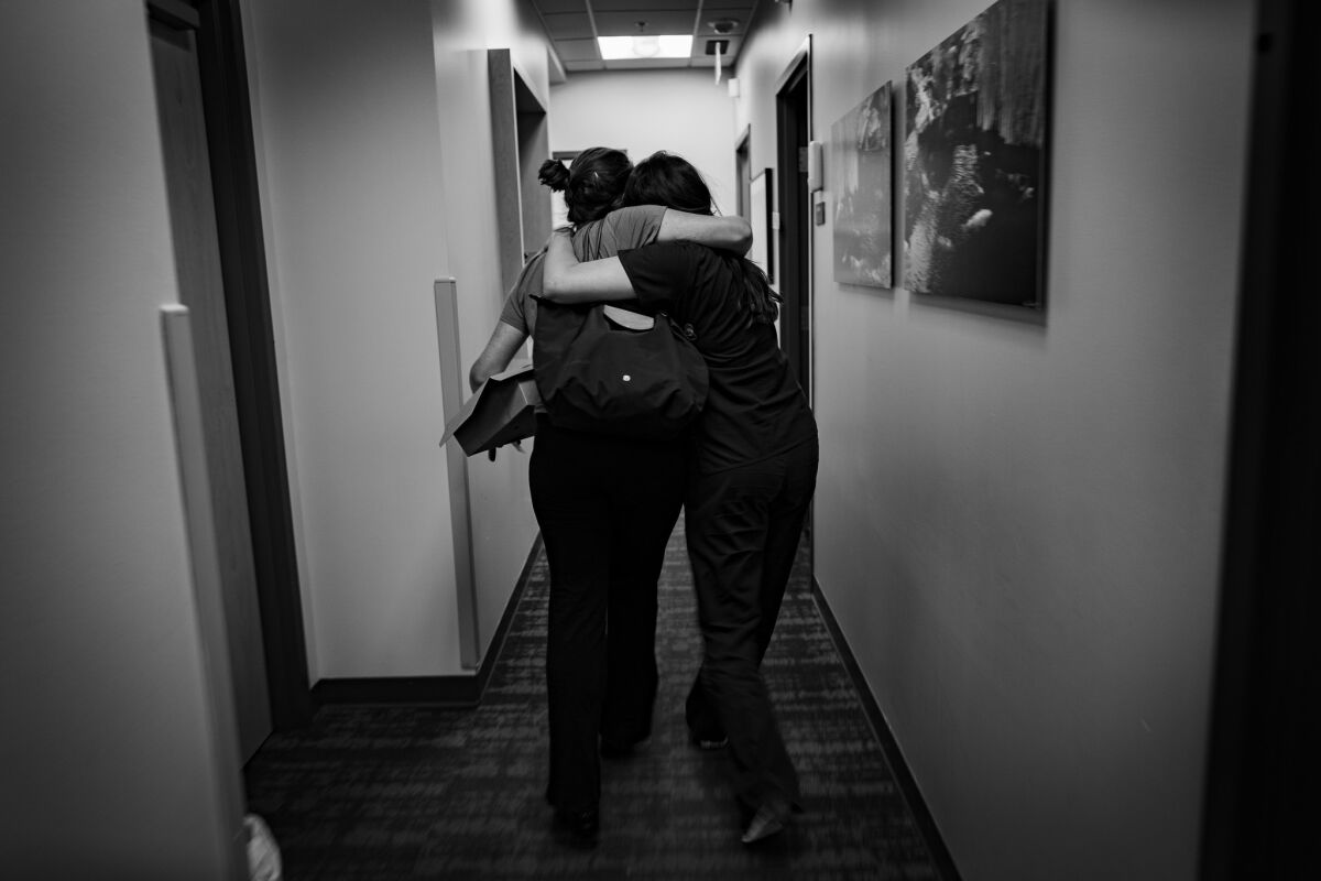 The doctor, left, and a clinic supervisor embrace as they leave the Dallas facility. (Gina Ferazzi / Los Angeles Times)