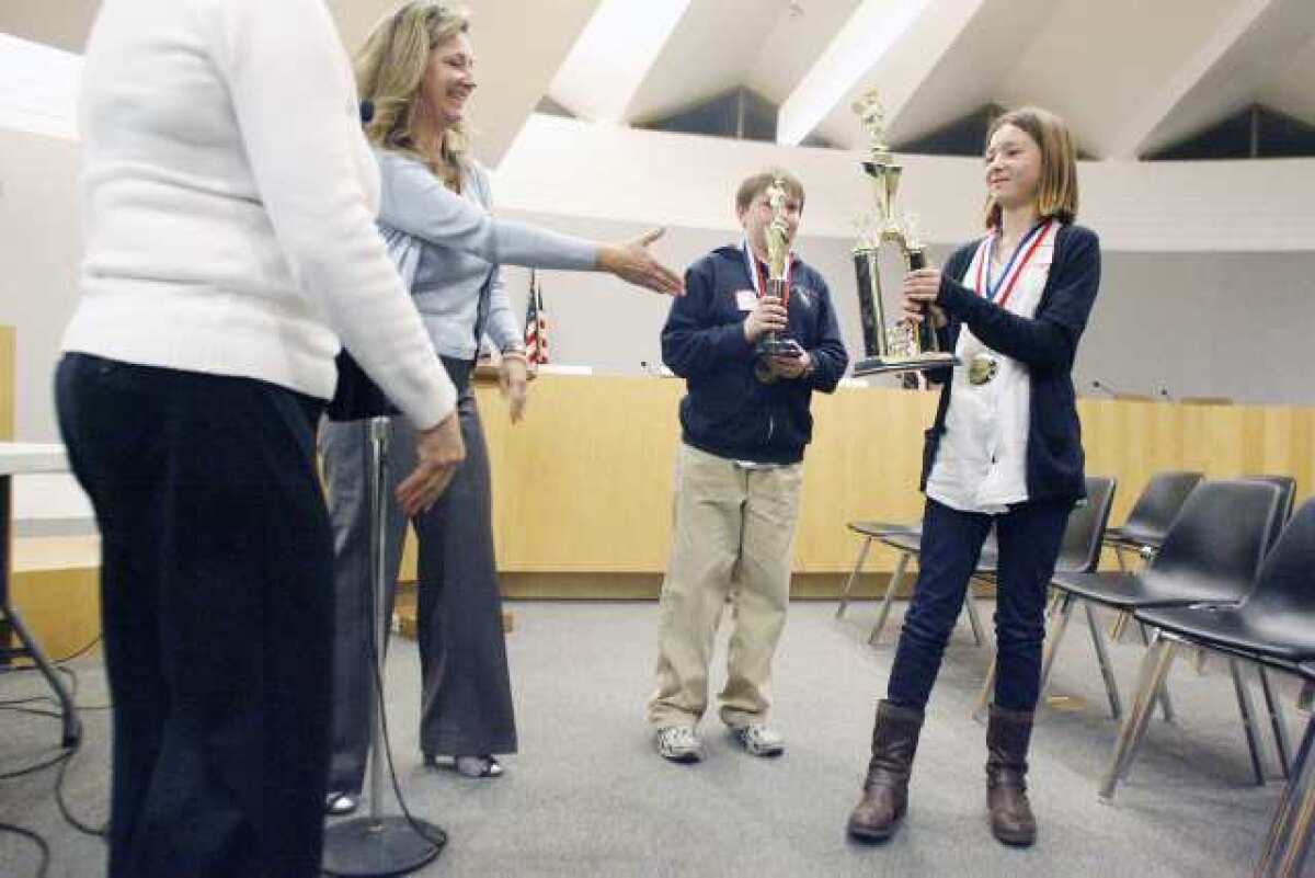 Debra Cradduck, from second left, congratulates Palm Crest Elementary's Solenn Matuska, far right, after winning the district's spelling bee contest in February. Palm Crest received top scores in a survey released last week.