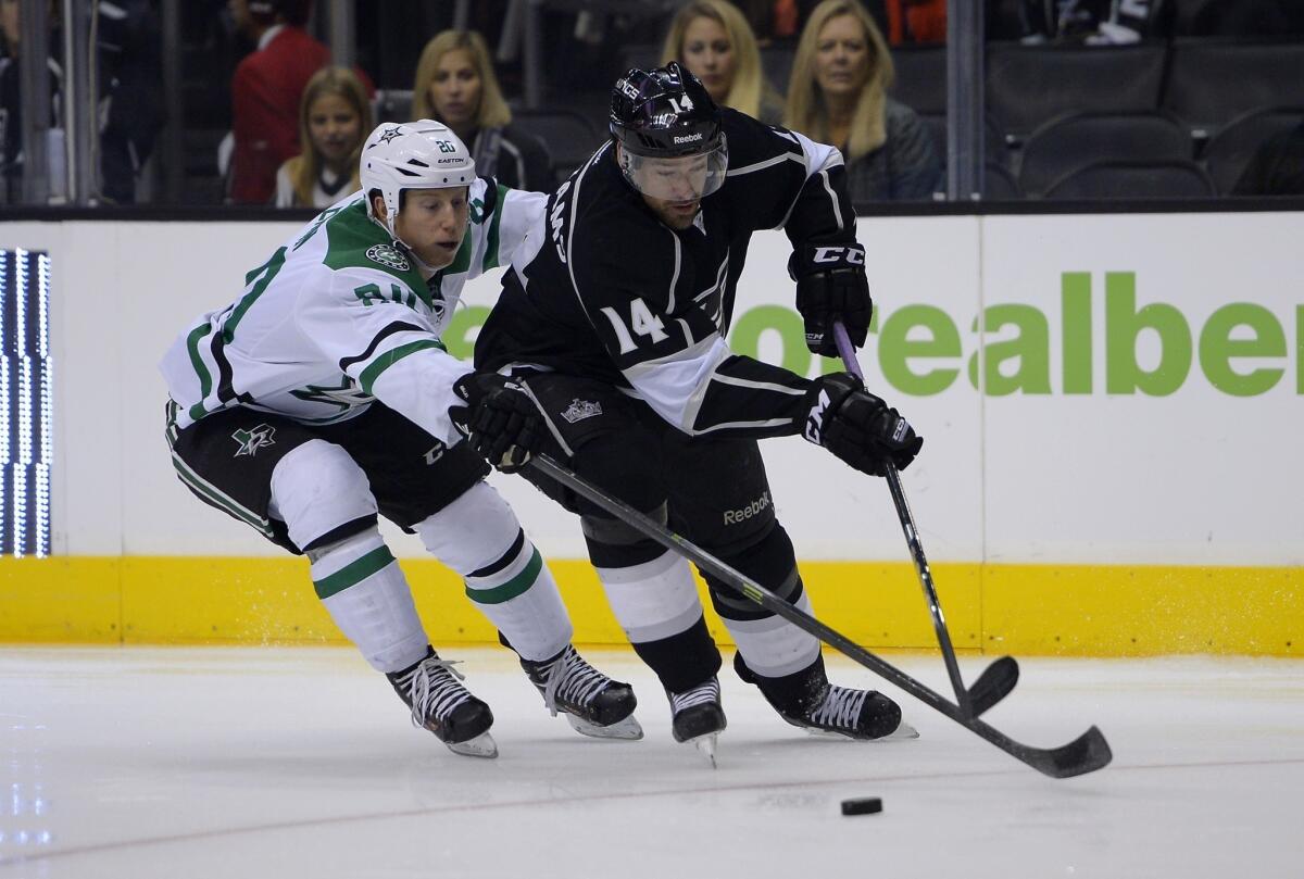 Kings right wing Justin Williams, right, controls the puck in front of Dallas center Cody Eakin during the Kings' win Saturday. The Kings appeared to have put last season's road demons behind them.