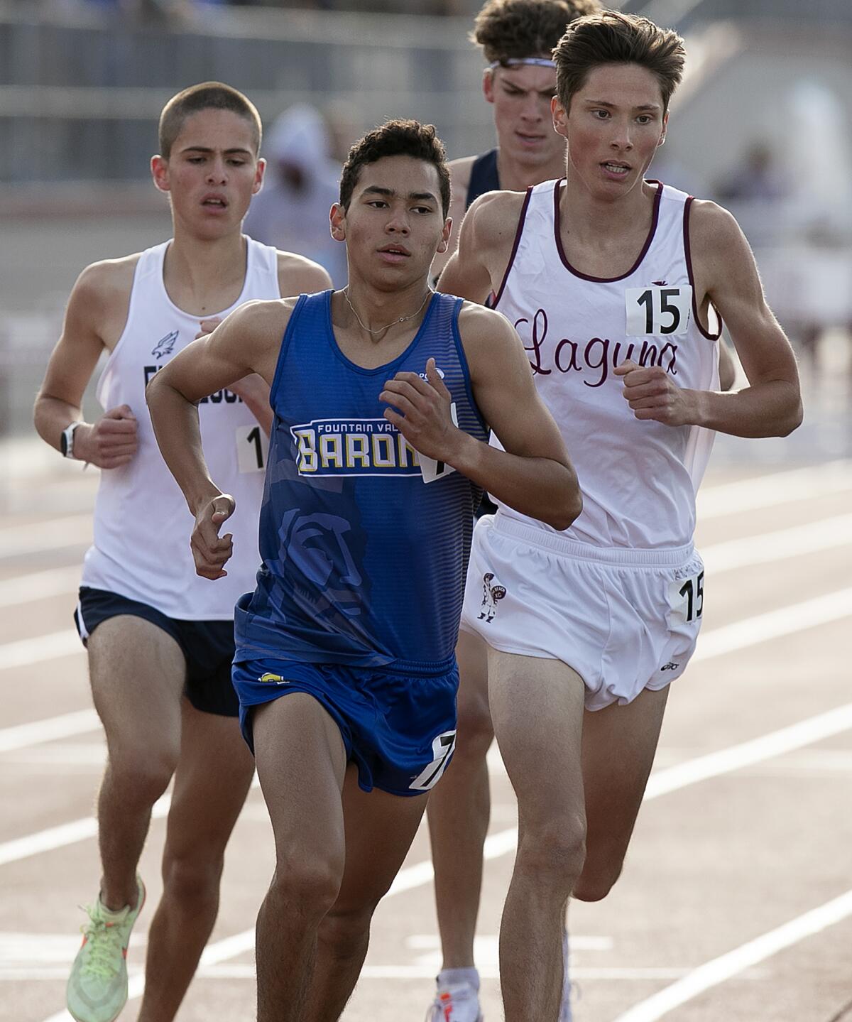 Fountain Valley's Benjamin Prado, center, and Laguna Beach's Mael Metis, right, compete in the boys' 3,200-meter run.