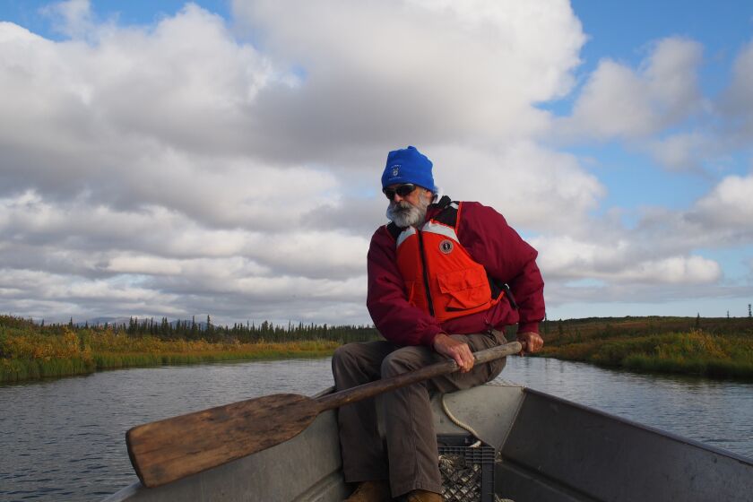 Jay Denton rows a boat along a creek off the Noatak River.