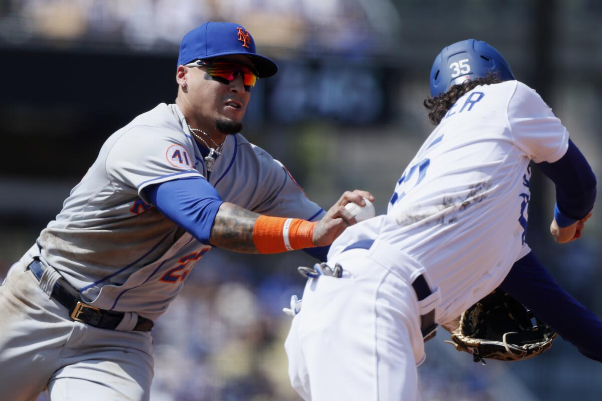 New York Mets shortstop Javier Baez, left, tags out Cody Bellinger on a steal-attempt 